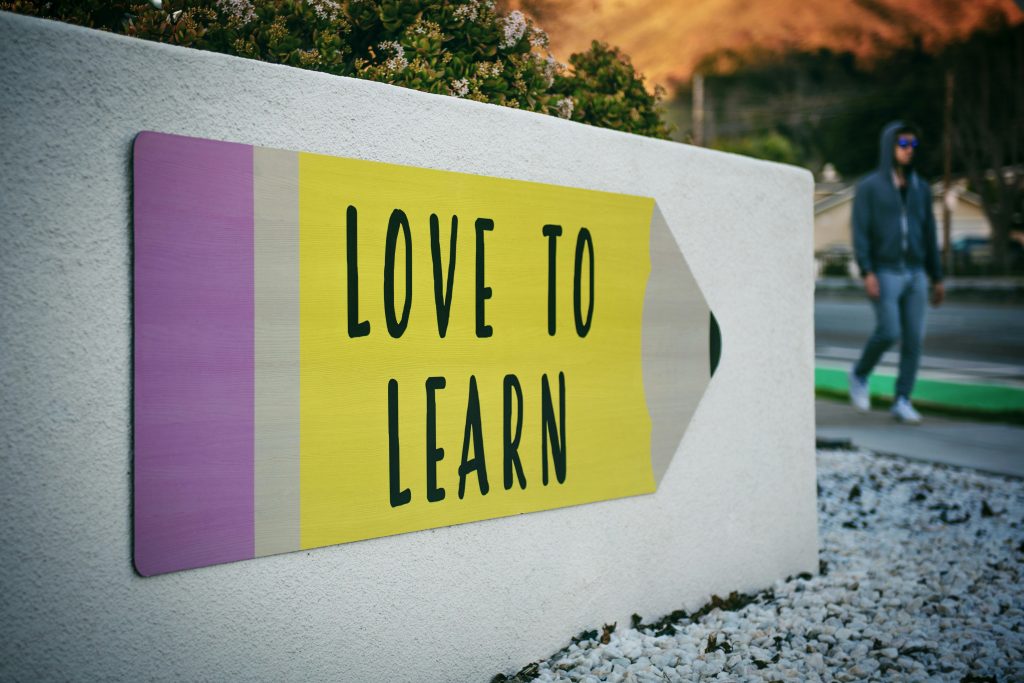 Large pencil painted on concrete with words Love To Learn